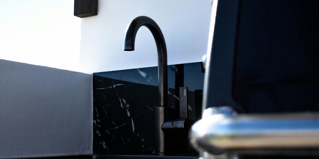 a kitchen sink with a black faucet next to it