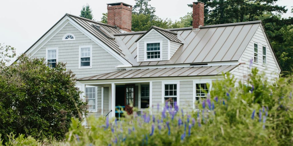 white and gray wooden house surrounded by green plants during daytime
